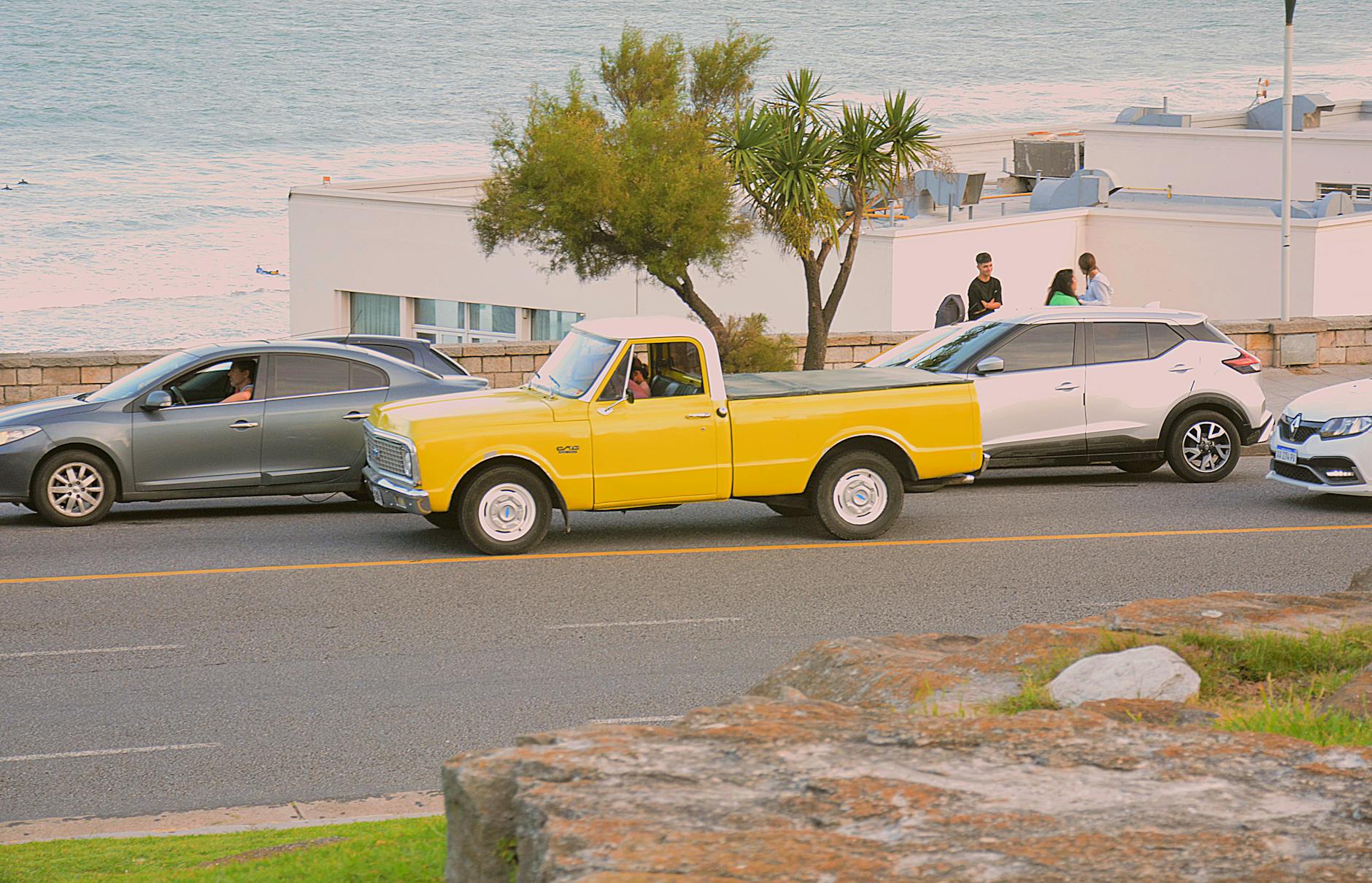 Żółta ciężarówka zaparkowana przy morzu w słoneczny dzień