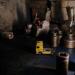 Przewodnik po oznaczeniach części Iveco i Kamaza, który ułatwi zamówienia w hurtowniach Koszalina Żółta miniaturowa ciężarówka wśród metalowych części w warsztacie