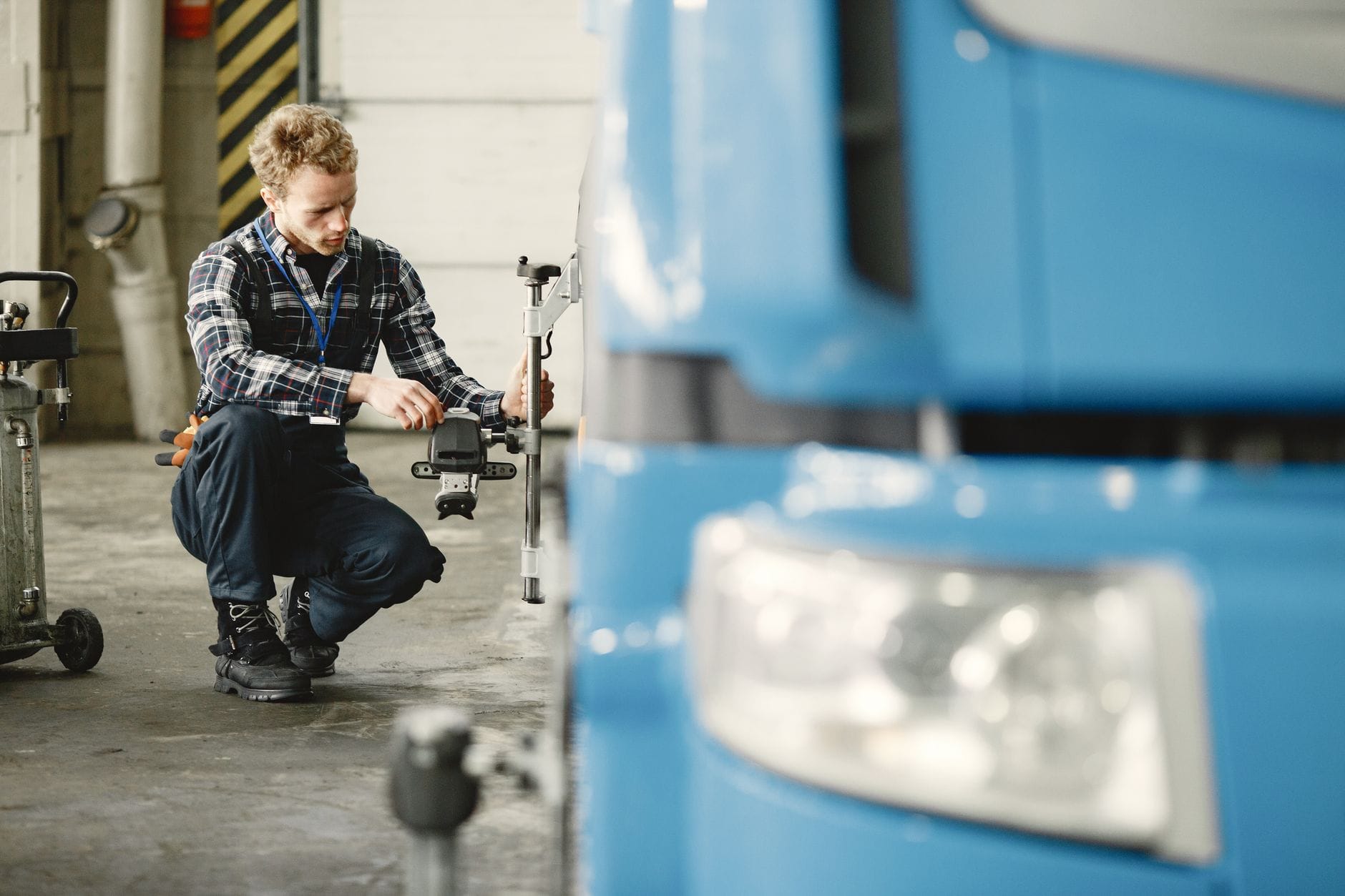 Mechanik ustawia koła ciężarówki Kamaz w warsztacie samochodowym